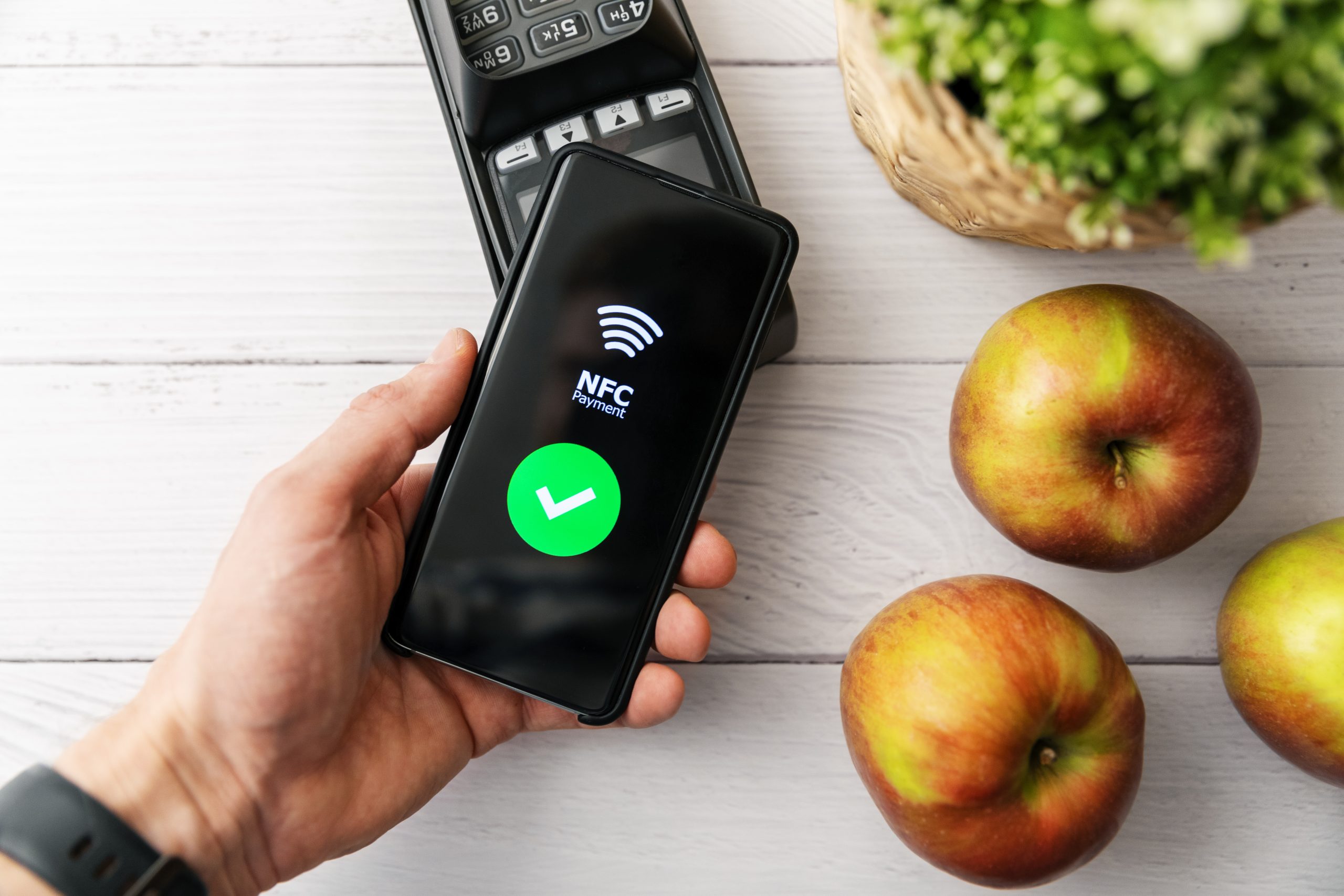 nfc contactless payment with phone at groceries store